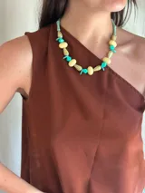 Collar corto con cuentas de cristales checos y acrílico en tonos celeste, crema y marrón. Se cierra con cadena de acero quirúrgico y ganchito para regular el largo.