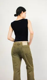 Pantalón jean negro de corte acampanado con abertura en los laterales.