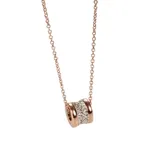 Collar con cadena fina color oro rosa y dije cilíndrico con centro de circonitas blancas y bordes lisos color oro rosa.