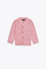 Chaqueta de punto color rosa con detalles en blanco, cuello redondo, manga francesa, bolsillos delanteros y cierre frontal con botones dorados.