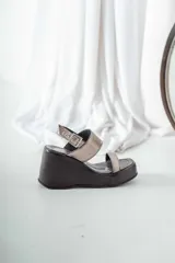 Sandalias de cuero color negro con plataforma y dos tiras plateadas.