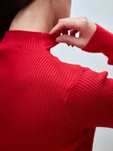 Polera de punto color crema, con cuello alto y mangas largas.