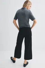 Pantalón de jean negro de corte ancho, tiro alto y largo cropped.