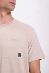 Remera color beige de manga corta con bolsillo en el pecho.