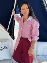 Camisa larga a rayas verticales rojas y blancas, con cuello y puños blancos.