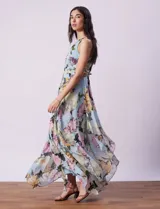 Vestido largo de gasa estampada con flores en tonos celeste, rosa y verde. Tiene cuello halter con abertura en forma de ojal, corte en la cintura con faja plisada y abertura central en la espalda con cierre invisible.