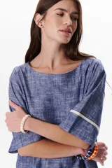 Blusa azul de lino con escote barco y mangas 3/4 con detalle de ribete blanco.
