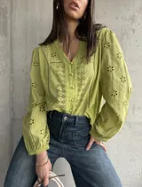 Camisa color verde pistacho con bordado calado de flores, cuello en V y mangas largas abullonadas.