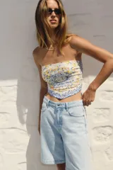 Bermuda de cinco bolsillos en denim de algodón, color celeste claro lavado. Modelo de tiro alto con cierre y botón.