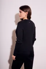 Cardigan negro de punto con cuello polo, manga larga y cierre frontal con botones.
