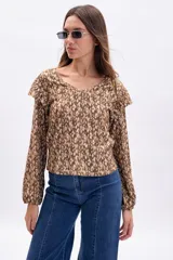 Blusa de manga larga con cuello en V y volados en los hombros. Presenta un estampado abstracto en tonos marrones y rosados claros.