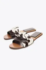 Sandalias planas con estampado animal, confeccionadas en piel con pelo. Presentan tiras cruzadas en la parte delantera y acabado en punta redonda. La altura de la suela es de 1 cm.
