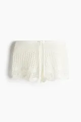 Short de playa tejido al crochet color blanco, con cintura elástica y cordón de ajuste.
