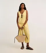 Musculosa sin mangas confeccionada en viscosa sostenible, con escote en pico y corte vertical.