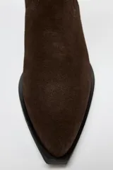 Bota alta de caña alta color marrón chocolate, de serraje con puntera fina y taco bajo.