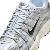 Championes urbanos Nike P-6000 color plateado y blanco con detalles en negro.