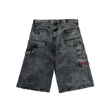 Bermuda de jean negro con efecto lavado, corte ancho y largo a la rodilla. Presenta bolsillos delanteros y traseros, etiqueta de marca en el bolsillo trasero y bordado rojo en la pierna derecha.