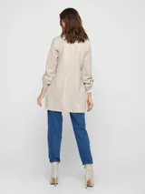 Abrigo largo color beige de gamuza sintética, con cuello solapa y mangas largas con lazo ajustable.