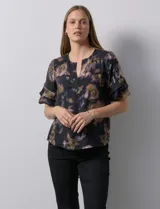 Blusa de gasa estampada con cuello a la base y escote en V. Tiene mangas cortas amplias con sobrecapas.
