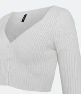 Cardigan corto blanco de punto acanalado con escote en V, mangas largas y cierre frontal con botones.