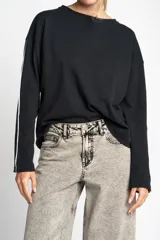 Sweater negro de algodón peinado con calce oversize y mangas largas con dos líneas blancas verticales.