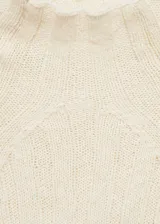 Sweater de punto color crema con cuello perkins y diseño de canalé vertical con aberturas.