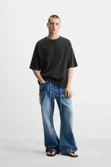 Camiseta negra de corte relaxed fit, cuello redondo y mangas cortas. Tejido de punto con textura acanalada y efecto lavado.