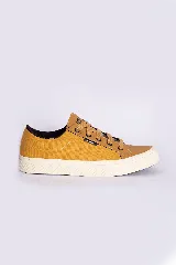 Zapatillas casuales color mostaza con cordones negros y suela blanca.