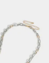 Collar corto con cadena de eslabones plateados y dorados, con dijes colgantes de corazones dorados con diferentes diseños.