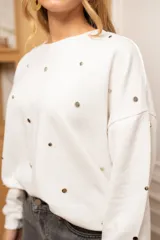 Sweater blanco de algodón con cuello redondo y mangas largas. Decorado con tachas plateadas en el frente y las mangas.