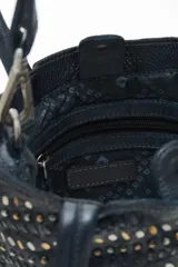 Cartera tote negra de cuero vacuno con tachas metálicas plateadas y doradas. Tiene doble asa corta y correa larga desmontable. Forro interior de algodón.