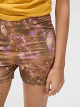 Short biker ajustado de lycra con estampado abstracto y difuminado en tonos verdes, naranjas, azules y rosados. Presenta costuras visibles en contraste y un pequeño logo bordado en la pierna derecha.