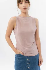 Musculosa color rosa metalizado, sin mangas, confeccionada en lino metalizado, con escote cerrado al frente y espalda abierta con lazo ajustable.