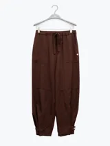 Pantalón estilo cargo color crudo, confeccionado en lino tencel. Cuenta con bolsillos laterales, elástico en la cintura y detalle de Polonio en cobre.