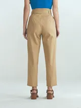 Pantalón de vestir color beige, de corte recto, con pinzas delanteras, bolsillos laterales y cinturón con hebilla forrada.