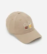Gorra de sarga color beige con ala curva y hebilla ajustable. Presenta un bordado frontal con dos vasos y las inscripciones '7am' y '7pm'.