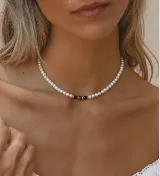 Gargantilla de perlas cultivadas con tres piedras naturales en el centro: una verde oscuro, una roja y una dorada.