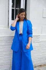 Blazer azul de lino, con solapa de muesca, cierre frontal con botones y bolsillos laterales.