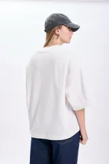 Remera blanca de corte amplio con mangas cortas anchas y cuello redondo.