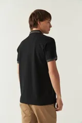 Remera cuello polo gris melange de manga corta, corte regular, con detalles de doble línea blanca en cuello y mangas, logo estampado en el pecho y confección en algodón.