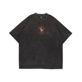Remera oversize negra con efecto acid wash y estampa frontal con una silla y el texto 'Kaboa Industries. Sin siesta no hay fiesta'.