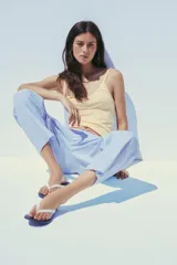 Pantalón tipo barrel con rayas verticales celestes y blancas, tiro medio y cintura elástica ajustable con lazo. Tiene bolsillos laterales y falsos bolsillos de vivo en la espalda.