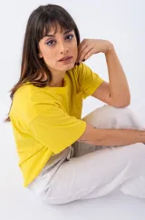 Remera amarilla de viscosa con escote redondo y bolsillo en el pecho.