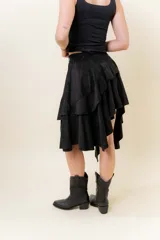 Pollera corta asimétrica de gamuza color marrón, con volados superpuestos y cintura elastizada. Incluye short interno.