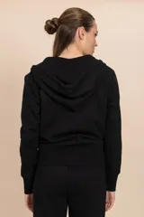 Chaqueta deportiva negra con cierre frontal, capucha con cordones ajustables y bolsillos laterales.