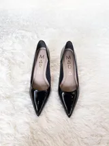 Zapato de tacón alto Iara, color negro charol, con punta fina y suela roja. Fabricado en cuero.