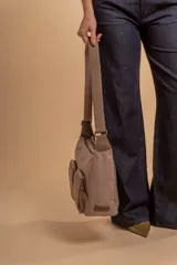 Bandolera de tafeta impermeable, liviana, con dos compartimientos principales, dos bolsillos con cierre y correa regulable con hebilla.