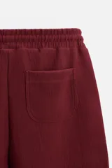 Bermuda negra de corte relaxed fit, con cintura elástica ajustable con cordón, bolsillos frontales y bolsillo trasero de parche.