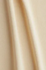 Musculosa color crema de punto fino, entallada, con escote en U en la parte delantera y trasera.