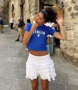 Remera azul con estampado frontal de la palabra "Italia" en letras blancas y la bandera italiana.